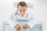 Overhead portrait of a smiling doctor using laptop