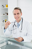 Smiling male doctor with digital tablet at medical office