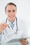 Portrait of a smiling male doctor with digital tablet