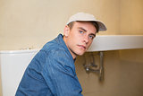 Serious male plumber by the sink