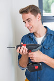 Handsome handyman using a drill