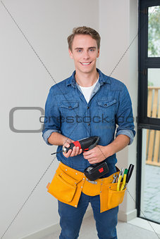 Handyman holding a drill with toolbelt around waist
