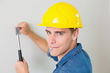 Close up of a handyman hammering nail in wall
