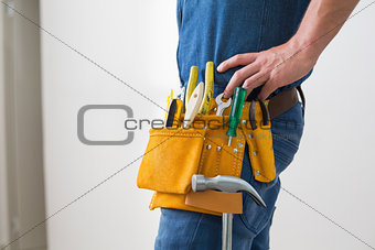 Mid section of handyman with toolbelt around his waist
