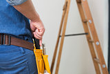 Mid section of a handyman with toolbelt