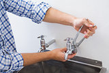 Plumber hand's fixing water tap with pliers