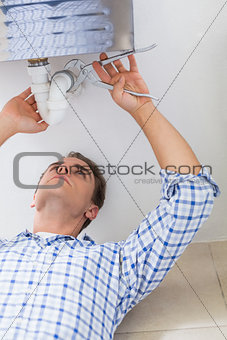 Plumber repairing washbasin drain in bathroom