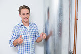 Technician gesturing thumbs up by hot water heater