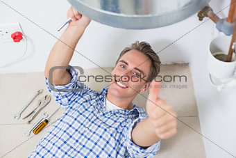 Technician gesturing thumbs up by hot water heater