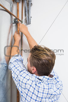 Technician servicing an hot water heater' pipes