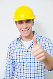 Smiling handyman in yellow hard hat gesturing thumbs up