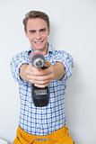Smiling handsome young handyman holding drill