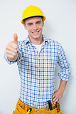 Portrait of a handyman in yellow hard hat gesturing thumbs up