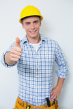 Portrait of a handyman in yellow hard hat gesturing thumbs up