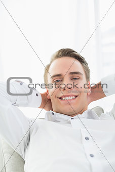 Smiling relaxed young man lying on sofa