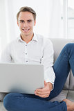 Portrait of a casual young man using laptop on sofa