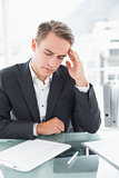 Businessman suffering from headache at office desk