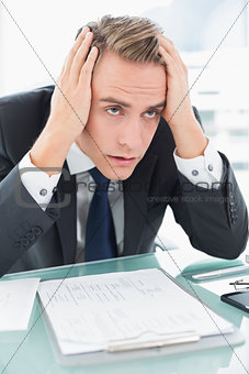 Worried young businessman at office desk