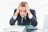Worried businessman sitting at office desk