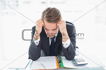 Worried businessman looking at documents in office