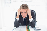 Portrait of worried businessman sitting at office desk