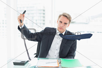 Businessman holding out phone at office