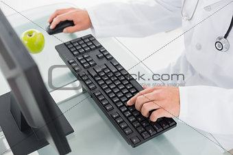 Mid section of doctor using computer