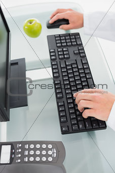 Hands using computer at medical office
