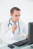 Doctor looking at computer in medical office
