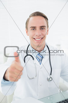 Smiling doctor gesturing thumbs up at medical office