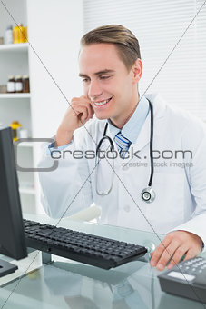 Smiling doctor using computer at medical office