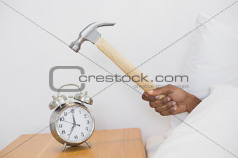Smashing alarm clock with hammer