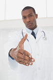 Serious male doctor offering a handshake