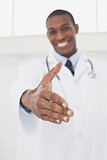 Smiling male doctor offering a handshake