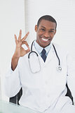 Male doctor gesturing okay sign at medical office