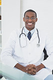 Smiling male doctor sitting at medical office
