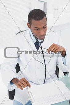 Concentrated doctor reading a note at medical office