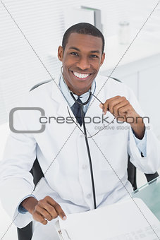 Male doctor sitting at desk in medical office