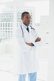 Doctor standing with arms crossed in a medical office