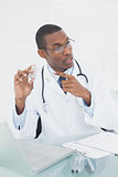 Doctor pointing at prescription bottle in medical office