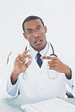 Male doctor pointing at prescription bottle