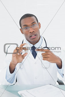 Male doctor pointing at prescription bottle
