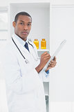 Serious doctor writing a prescription in medical office