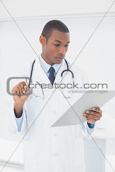 Serious male doctor writing a prescription