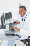 Smiling doctor using computer at medical office