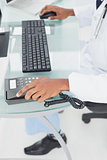 Low section of doctor using computer at medical office
