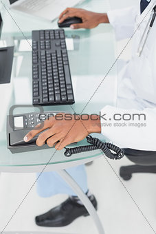 Low section of doctor using computer at medical office