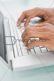 Hands using laptop at medical office