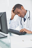 Worried male doctor using computer