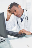 Portrait of a serious male doctor using computer